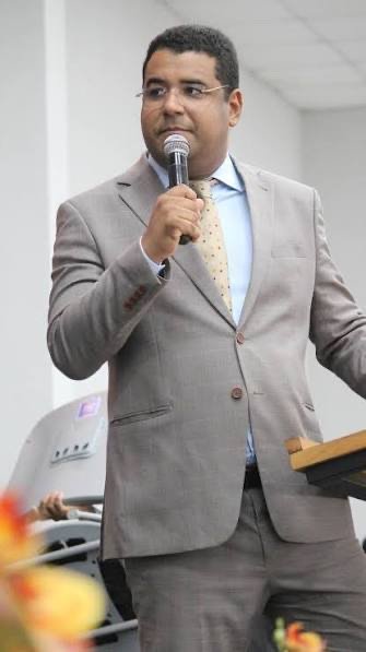 Pr. Jonatas Lins falando ao público diante de um púlpito